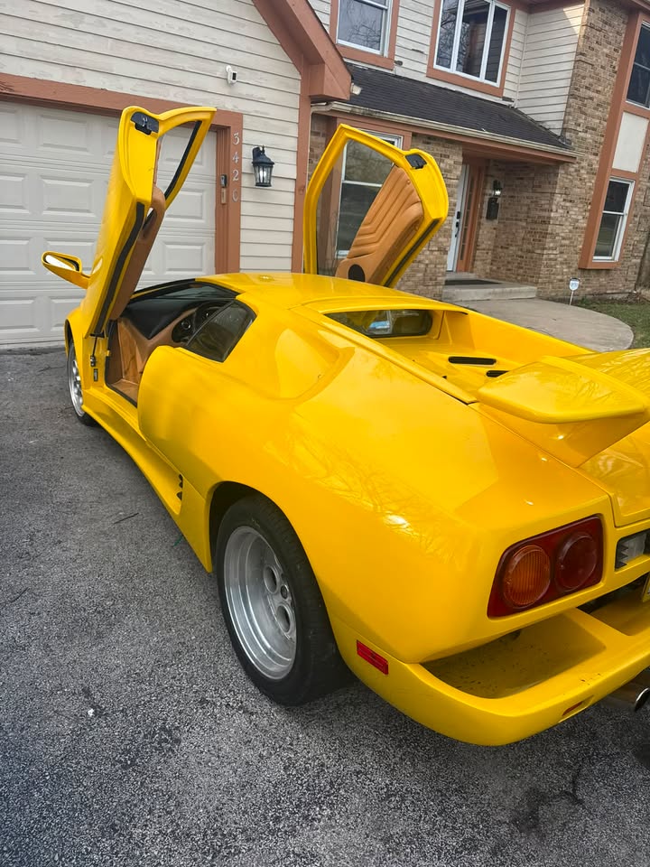 Yellow Lamborghini Diablo with scissor doors open after a detail